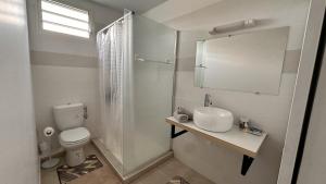 a white bathroom with a toilet and a sink at Vista - Route des plages - Destination Guyane in Rémire-Camp +14 photos