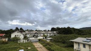 a group of houses on a hill with a cloudy sky at Vista - Route des plages - Destination Guyane in Rémire-Camp