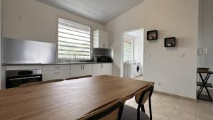 a kitchen with a wooden table and a kitchen with a sink at Vista - Route des plages - Destination Guyane in Rémire-Camp