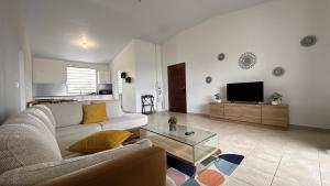 a living room with a couch and a tv at Vista - Route des plages - Destination Guyane in Rémire-Camp