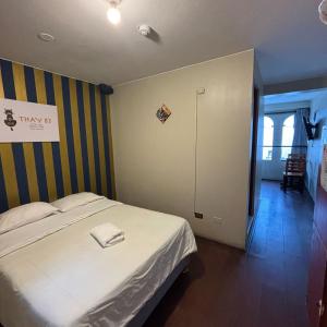 a bedroom with a bed and a striped wall at Miraflores Thay Colonial in Lima