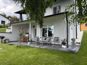 a patio with chairs and a statue in front of a house at Chalet Weiß in Mönichkirchen