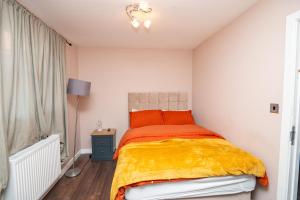 a bedroom with a bed with a yellow blanket at Elegant and Modern Apartment 3 Double Bedroom Near City Centre Entire House Parking in Manchester