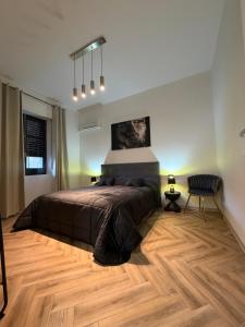 a bedroom with a large bed and a chair at Casa Amore Design - South Sardinia - in San Gavino Monreale