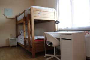 a bedroom with a bunk bed with a desk and a desk at Casa Seblina in Ostend
