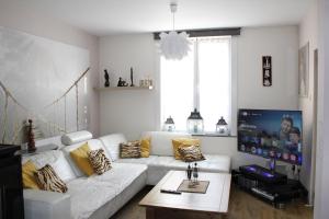 a living room with a white couch and a table at Casa Seblina in Ostend