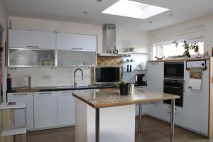 a kitchen with white cabinets and a wooden table at Casa Seblina in Ostend