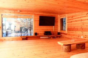 a log cabin with a television and a wooden floor at Rahkis Lodge Saariselkä in Saariselka