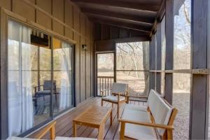 eine Veranda mit zwei Stühlen und einem Tisch darauf in der Unterkunft Rustic Ridge in Gentry