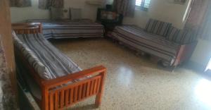 a room with two beds and a bed and a window at Swanky Homestay GHAR wali feeling in Kolhapur