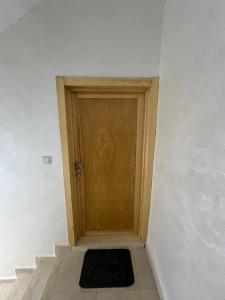 a wooden door in a white room with a rug at Florida Waves in El Jadida
