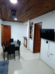 a dining room with a table and a tv on a wall at Glamar Apartamento in Arboletes