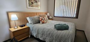 a bedroom with a bed and a night stand with a lamp at Serendipity On Barrington in Barrington +15 photos