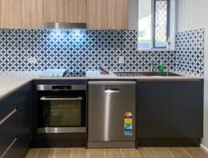 a kitchen with a stainless steel stove and a sink at The Mooloolaba Gallery in Mooloolaba