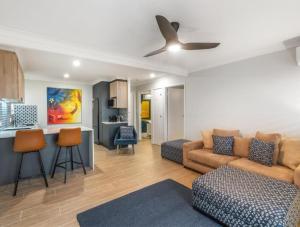 a living room with a couch and a kitchen at The Mooloolaba Gallery in Mooloolaba