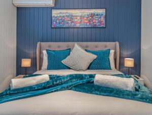 a bedroom with a large bed with blue walls at The Mooloolaba Gallery in Mooloolaba +11 photos