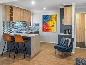 a kitchen with two chairs and a counter in a room at The Mooloolaba Gallery in Mooloolaba