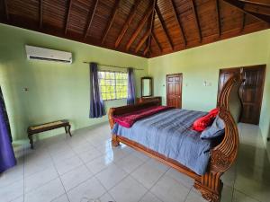 a bedroom with a wooden bed in a room at Quiet Escape Unity Hall in Montego Bay