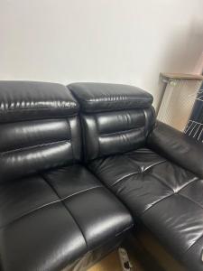 a black leather couch in a living room at Bagneux cozy in Châtillon +1 photo