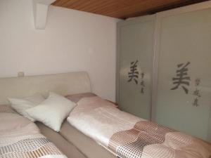 グライツにあるFerienwohnung Kopp Iのベッド2台 アジア文字が壁に描かれた部屋