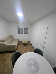a living room with a couch and a table at Montana apartman in Han Pijesak