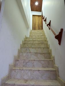 a set of stairs with a wooden door at Glamar Apartamento in Arboletes