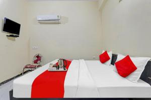 a room with a bed with red and white pillows at Hotel O by OYO Sunrise Inn in Gorakhpur +21 photos