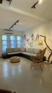 a living room with a couch and a chair at Casa Aroeira Sahy in Barra do Sahy