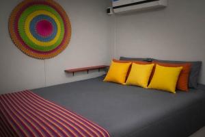 a room with a bed with yellow and orange pillows at Cerveceria BEERDIER Alojamiento in Salto