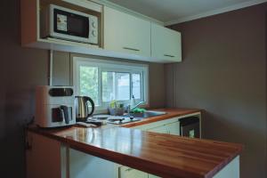 a kitchen with a counter top and a microwave at Cerveceria BEERDIER Alojamiento in Salto