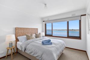 a bedroom with a large bed with a large window at River Meets Ocean Edge - Absolute Waterfront in Barwon Heads
