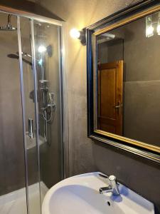 a bathroom with a sink and a shower with a mirror at Santocasale in Rocca di Mezzo