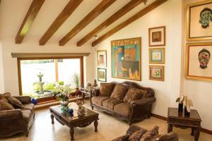 a living room with leather couches and a large window at BUHO Luxury Guayllabamba Home BBQ Jacuzzi Pool in Quito +45 photos