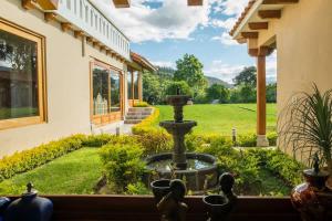 a garden view from a window of a house with a fountain at BUHO Luxury Guayllabamba Home BBQ Jacuzzi Pool in Quito