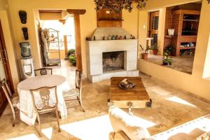 a living room with a fireplace and a table at BUHO Luxury Guayllabamba Home BBQ Jacuzzi Pool in Quito