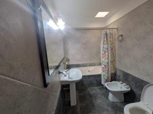 a bathroom with a sink and a toilet and a tub at Apartamento céntrico Campana in Campana +2 photos