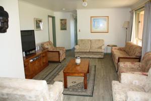 uma sala de estar com sofás e uma mesa de centro em Maslin Beach House em Maslin Beach
