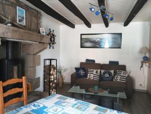 a living room with a couch and a fireplace at Maison en pierre pour 6-jardin &animaux bienvenus in Languidic