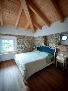 ein Schlafzimmer mit einem Bett und einer Steinwand in der Unterkunft Cà Bianca in Erba