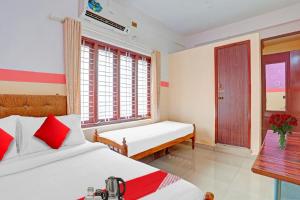 a hotel room with two beds and a window at SPOT ON The New View Regency in Trivandrum