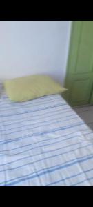 a bed with a blue and white sheets and a pillow at Pelourinho in Salvador