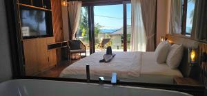 ein Schlafzimmer mit einem Bett mit Badewanne und einem Fenster in der Unterkunft Villa Trident Srithanu Koh Phangan 2 min of Zen Beach in Ko Kong Nui