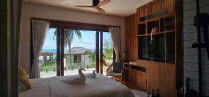 ein Schlafzimmer mit einem Bett, auf dem zwei Schwäne abgebildet sind in der Unterkunft Villa Trident Srithanu Koh Phangan 2 min of Zen Beach in Ko Kong Nui