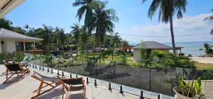 ein Balkon mit Stühlen und Blick auf den Strand in der Unterkunft Villa Trident Srithanu Koh Phangan 2 min of Zen Beach in Ko Kong Nui
