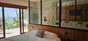 ein Schlafzimmer mit einem Bett, einem Fenster und einem Kissen in der Unterkunft Villa Trident Srithanu Koh Phangan 2 min of Zen Beach in Ko Kong Nui + 28 Fotos
