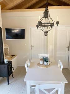 a dining room with a white table and a chandelier at House Sea la vie in Murter
