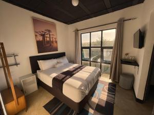 a bedroom with a bed and a large window at Ocean Garden GuestHouse in Ispongo