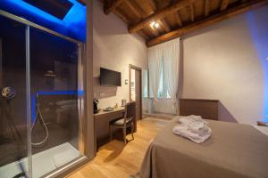 トラーニにあるDimora Corteinfioreのベッド、デスク、シャワーが備わる客室です。