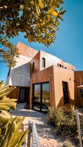 a large wooden building with glass doors at Locus Solus Hotel Singular in Mar del Plata