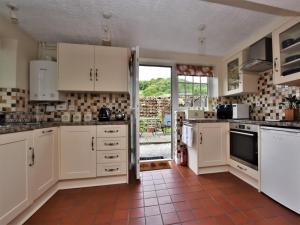 a kitchen with white cabinets and an open door at 2 Bed in Eyam oc-pk812 in Eyam +6 photos